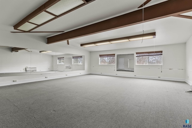 1205 Douglas Ave, Yankton, SD 57078 - unfurnished living room with beam ceiling, baseboards, and carpet flooring
