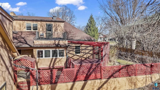 1205 Douglas Ave, Yankton, SD 57078 - view of property exterior featuring a shingled roof, a chimney, fence, a balcony, and brick siding