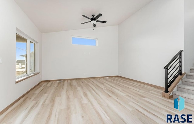 5709 S Spirea Ave, Sioux Falls, SD 57106 - spare room with baseboards, stairway, light wood-style flooring, a ceiling fan, and lofted ceiling