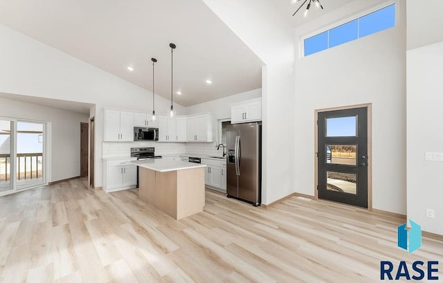 5709 S Spirea Ave, Sioux Falls, SD 57106 - kitchen featuring light wood-style floors, a center island, light countertops, a sink, and stainless steel appliances