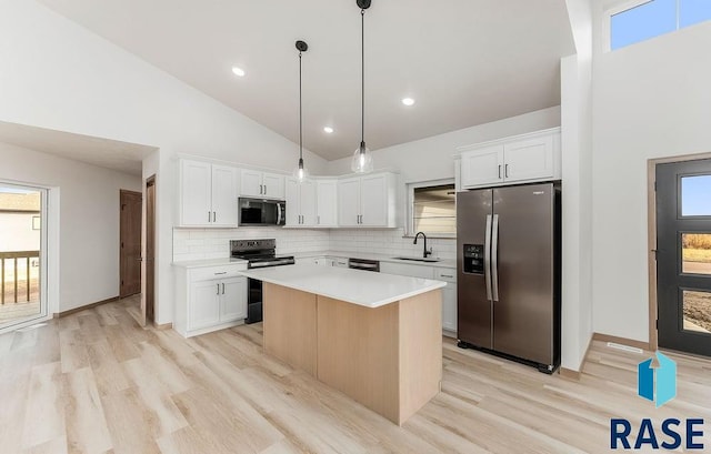 5709 S Spirea Ave, Sioux Falls, SD 57106 - kitchen with white cabinets, a sink, light countertops, appliances with stainless steel finishes, and a kitchen island