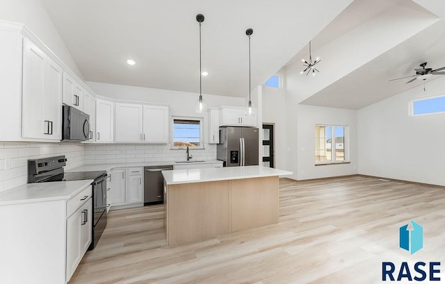 5709 S Spirea Ave, Sioux Falls, SD 57106 - kitchen with tasteful backsplash, a kitchen island, black appliances, light wood finished floors, and a sink