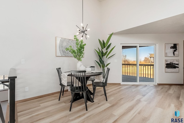 5709 S Spirea Ave, Sioux Falls, SD 57106 - dining room with light wood-style flooring, a towering ceiling, a notable chandelier, and baseboards