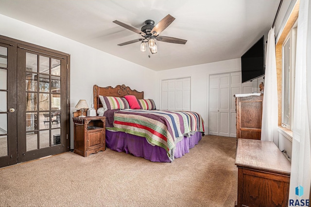 bedroom with carpet floors, multiple closets, and ceiling fan