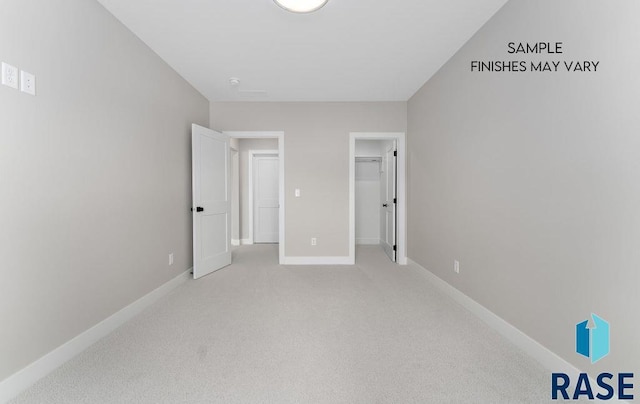 8312 E Wicker Ct, Sioux Falls, SD 57110 - unfurnished bedroom with light carpet, baseboards, and a walk in closet