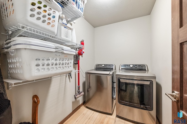 laundry area with light wood-style flooring, independent washer and dryer, and laundry area