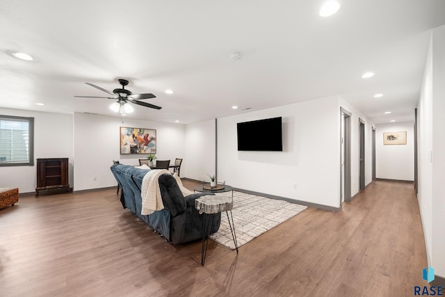 living room featuring light wood finished floors, baseboards, and recessed lighting