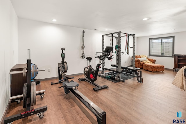 workout room with recessed lighting and wood finished floors