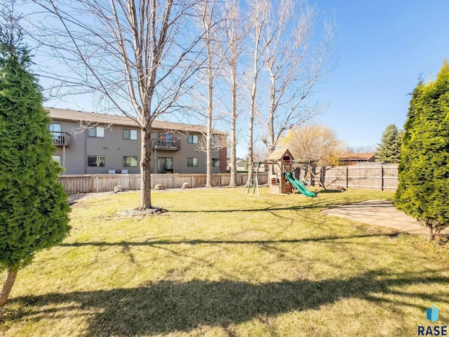 view of yard with fence, a residential view, and a playground