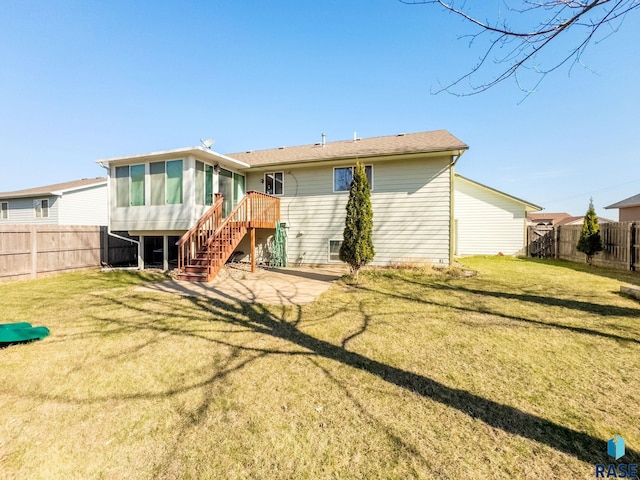 back of property featuring stairs, a fenced backyard, a sunroom, and a lawn