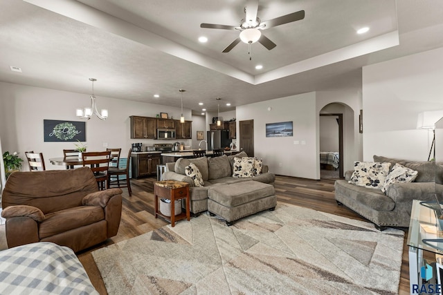 living room with recessed lighting, arched walkways, wood finished floors, and ceiling fan with notable chandelier