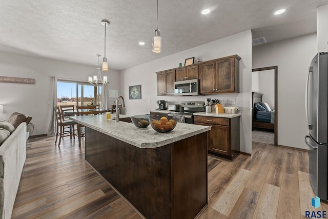 kitchen featuring recessed lighting, light countertops, stainless steel appliances, a sink, and wood finished floors