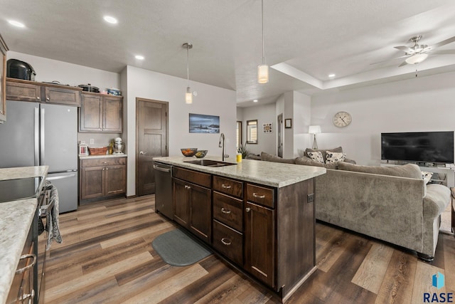 kitchen with appliances with stainless steel finishes, recessed lighting, an island with sink, dark wood finished floors, and a sink