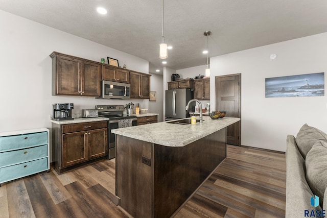 kitchen featuring a sink, light countertops, dark brown cabinetry, dark wood-style floors, and stainless steel appliances