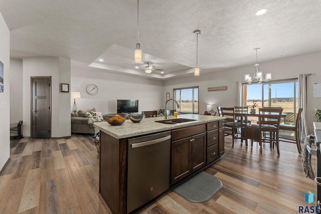 kitchen with dark brown cabinetry, open floor plan, dark wood-type flooring, dishwasher, and a sink