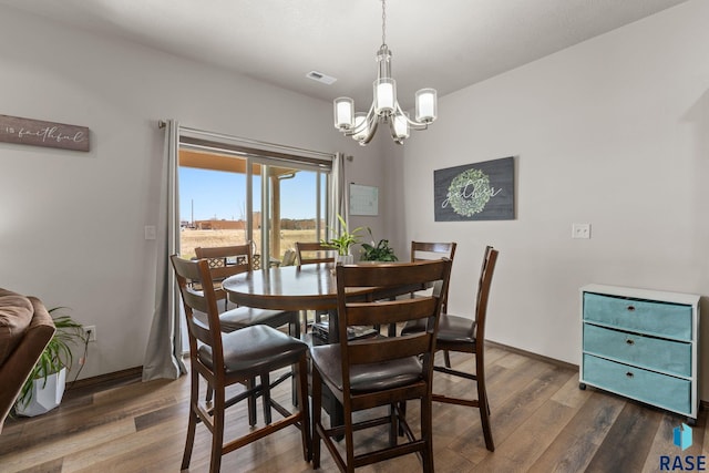 dining room with a chandelier, baseboards, dark wood finished floors, and visible vents