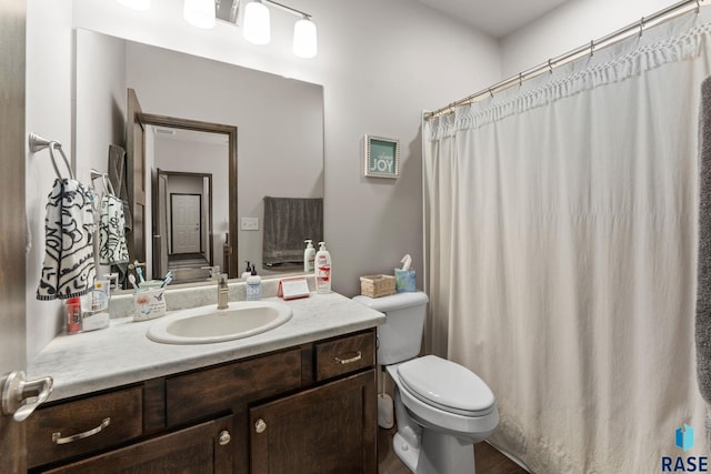 bathroom with a shower with shower curtain, vanity, and toilet