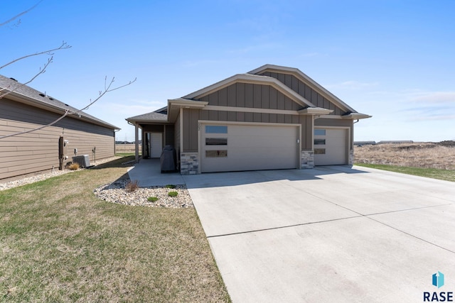view of front facade featuring driveway, cooling unit, board and batten siding, a front yard, and a garage