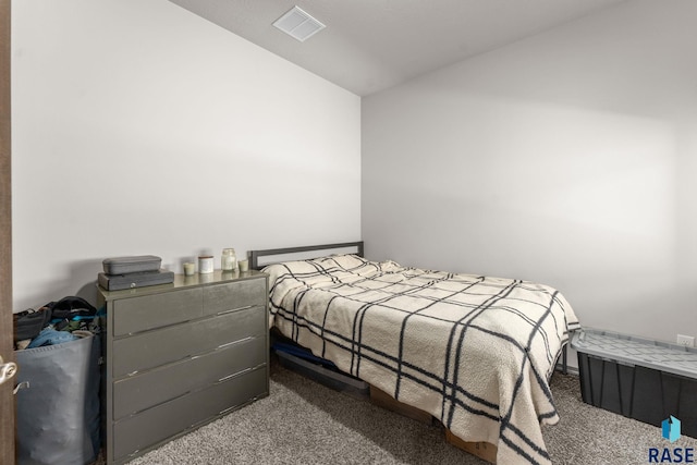 bedroom with carpet, visible vents, and vaulted ceiling