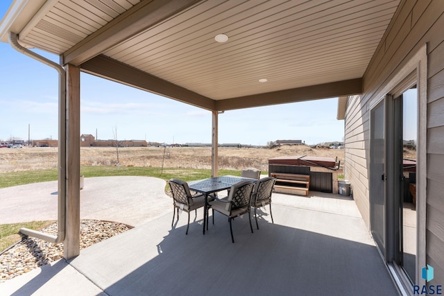 view of patio with outdoor dining space and a hot tub