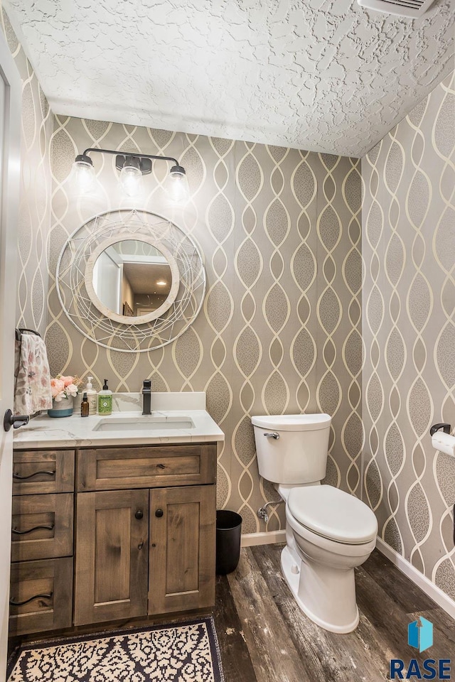 bathroom featuring wood finished floors and wallpapered walls