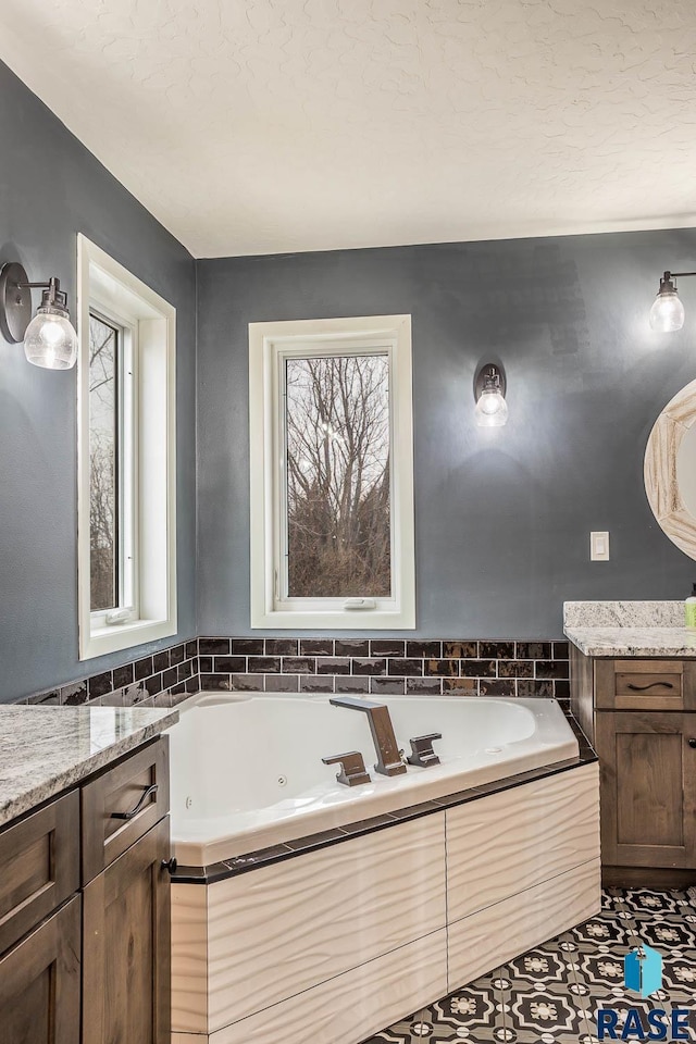 bathroom featuring a jetted tub and vanity