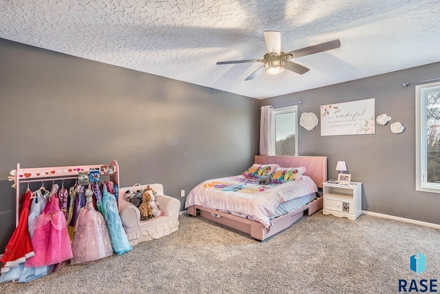 carpeted bedroom with ceiling fan, baseboards, and a textured ceiling
