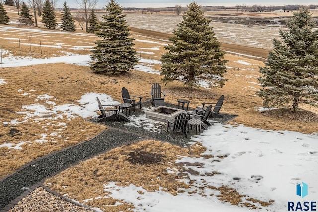 yard layered in snow featuring an outdoor fire pit