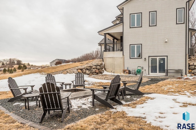 snow covered patio with an outdoor fire pit