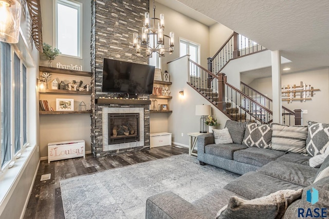 living room with a fireplace, baseboards, an inviting chandelier, and wood finished floors