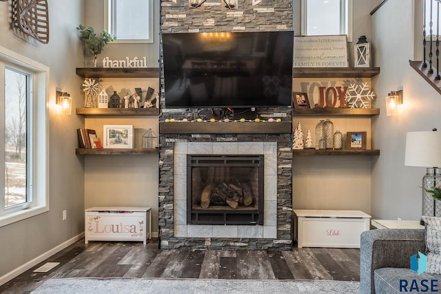 living area featuring visible vents, baseboards, wood finished floors, and a fireplace