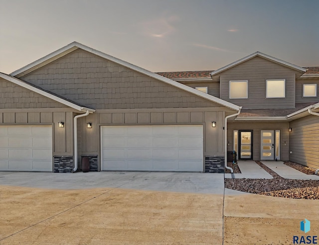 23744 461a Ave # 2, Wentworth, SD 57075 - view of property featuring concrete driveway, stone siding, and an attached garage