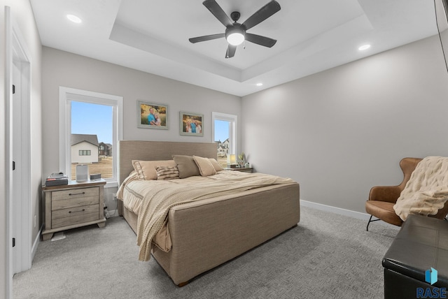 bedroom featuring a tray ceiling, light colored carpet, a ceiling fan, recessed lighting, and baseboards