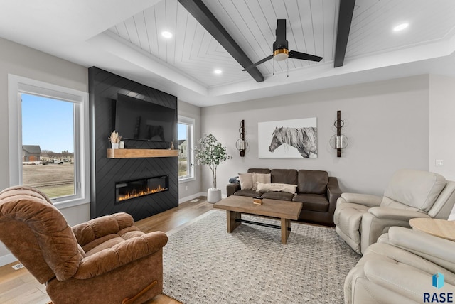 living area featuring a large fireplace, baseboards, light wood finished floors, and recessed lighting