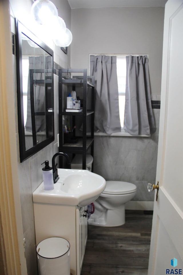 bathroom featuring tile walls, wood finished floors, a wealth of natural light, and toilet