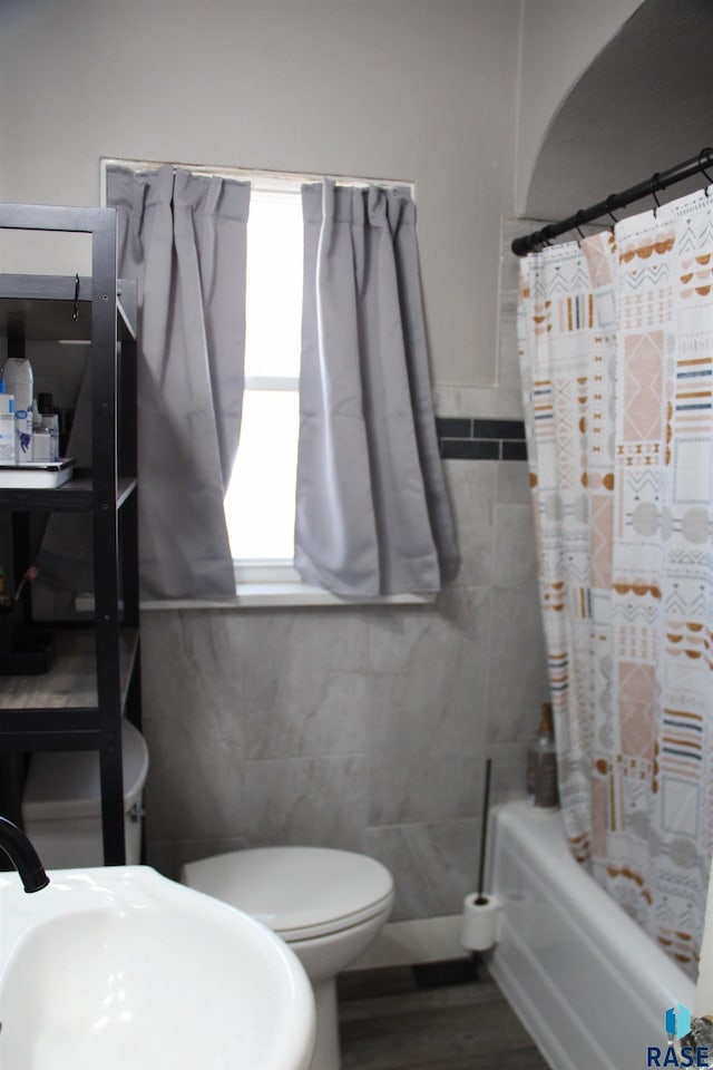 full bath with tile walls, wood finished floors, a sink, and toilet