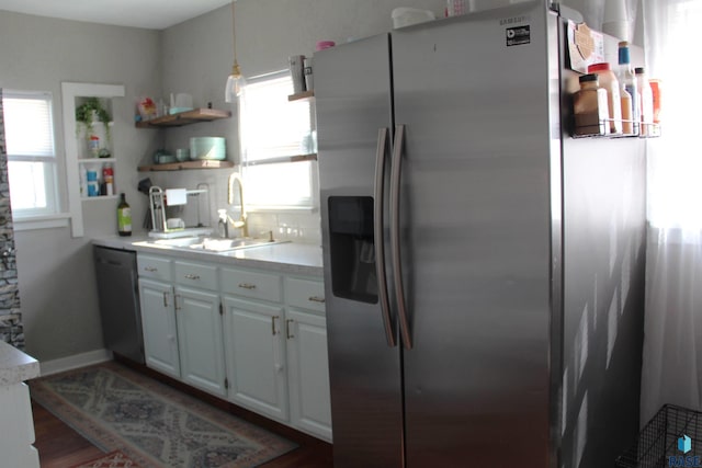 kitchen featuring open shelves, a sink, stainless steel fridge, dishwasher, and a healthy amount of sunlight