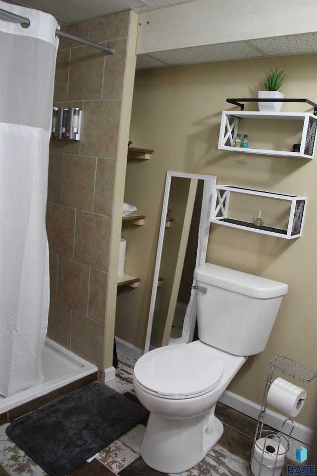 full bathroom featuring baseboards, toilet, and a stall shower