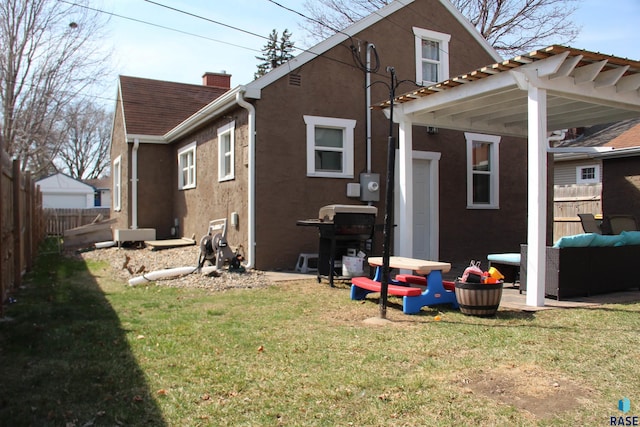 back of house featuring stucco siding, fence, a yard, and an outdoor hangout area