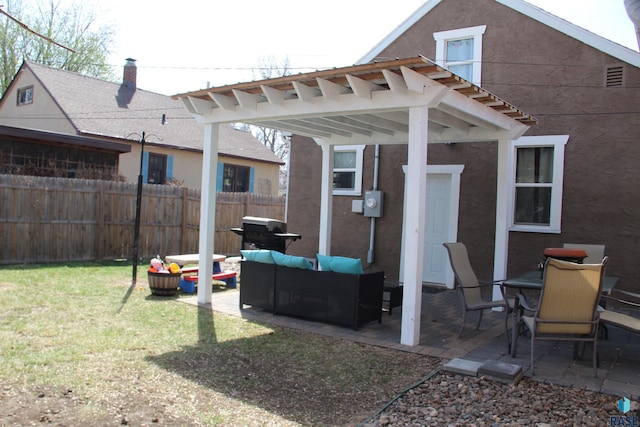 rear view of house featuring an outdoor living space, a patio area, fence, and a yard