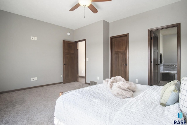 bedroom with baseboards, ensuite bath, a ceiling fan, visible vents, and light colored carpet