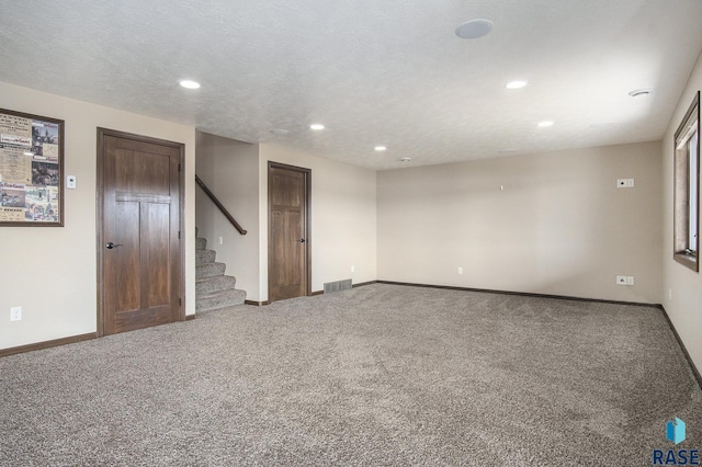 spare room featuring stairs, carpet, visible vents, and baseboards