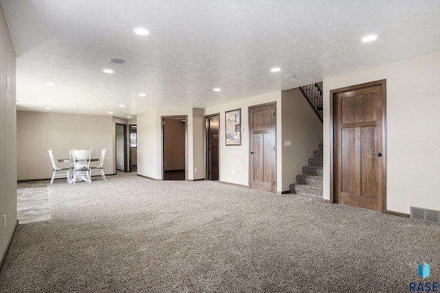 living room with recessed lighting, baseboards, visible vents, and stairway