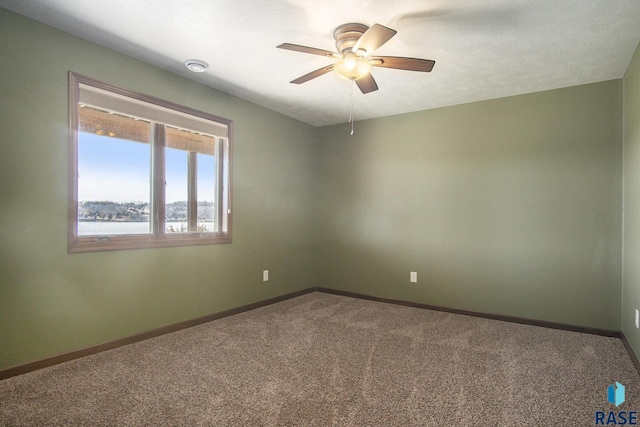 unfurnished room featuring carpet, baseboards, and ceiling fan