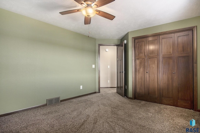 unfurnished bedroom with visible vents, baseboards, a closet, ceiling fan, and carpet