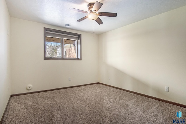 spare room featuring ceiling fan, carpet flooring, and baseboards