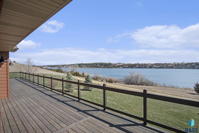 wooden terrace featuring a water view and a yard