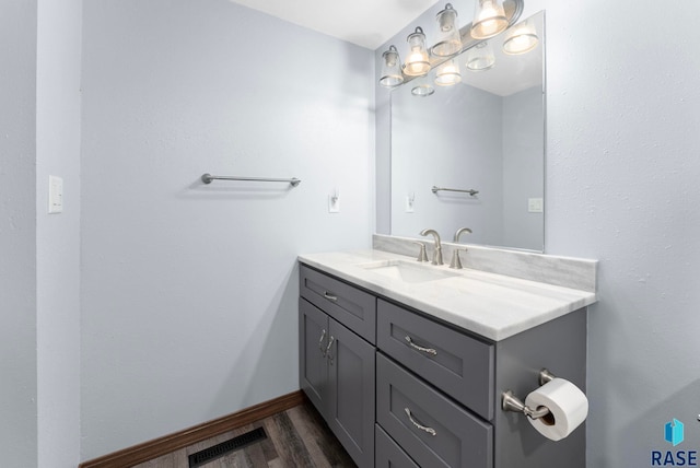 3325 E Manor Cir, Sioux Falls, SD 57103 - bathroom with wood finished floors, vanity, baseboards, and visible vents
