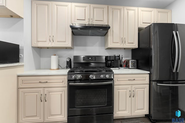 3325 E Manor Cir, Sioux Falls, SD 57103 - kitchen with under cabinet range hood, cream cabinets, and black appliances