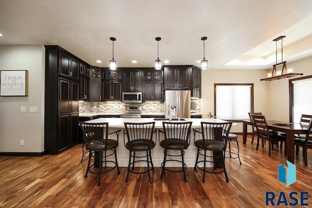 105 N Nora St, Viborg, SD 57070 - kitchen with glass insert cabinets, baseboards, light countertops, stainless steel appliances, and decorative backsplash